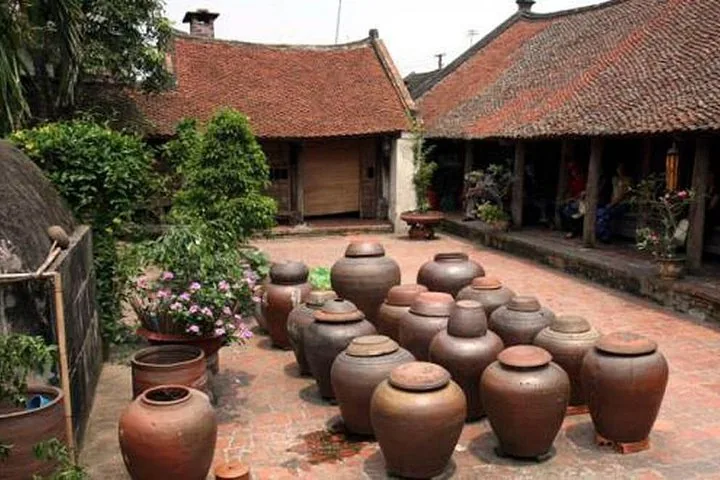 Grandi giare di ceramica sono esposte nel cortile di una casa tradizionale.