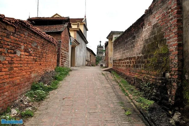 Uno stretto vicolo con muri in mattoni grezzi che attraversa un antico villaggio.